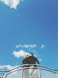 Low angle view of couple by railing