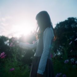 Side view of a woman standing on landscape