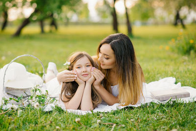 A beautiful mother and her daughter are lying on the beach and relaxing in the fresh air