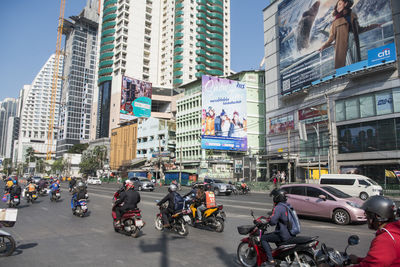 Vehicles on road by buildings in city