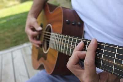 Midsection of man playing guitar