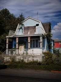 Old building by road against sky