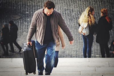 People walking on footpath in city