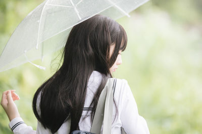Portrait of woman holding umbrella during rainy season