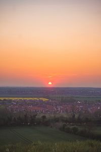 Scenic view of field against orange sky