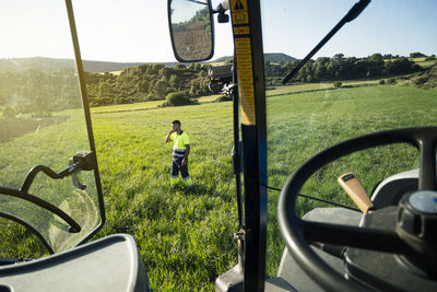 Young farmer standing in field on sunny day