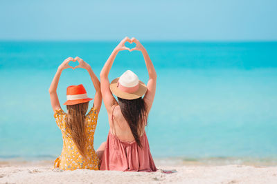 Woman wearing hat on beach against sea