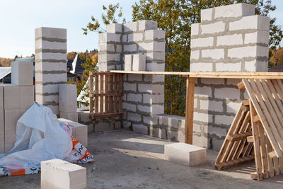 Stack of garbage by building against sky