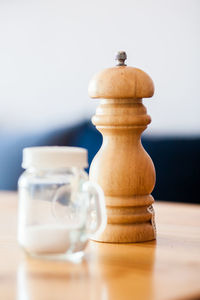 Close-up of pepper mill and salt on table
