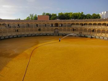 Man sprinkling water at bullfight stadium