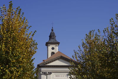 Low angle view of trees and building against sky