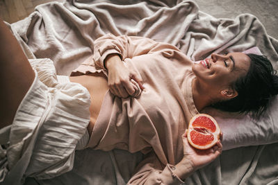 Portrait of young woman lying on bed