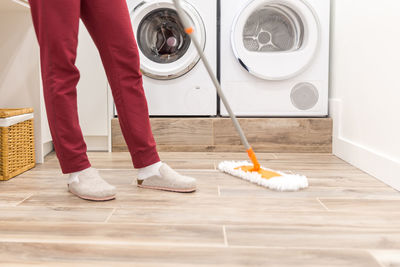 Low section of person cleaning floor