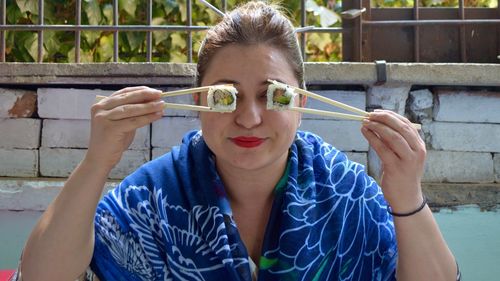 Close-up of woman having sushi with chopsticks