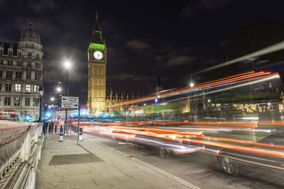 Light trails by big ben in city at night