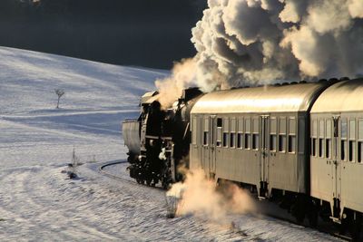 Train on railroad track against sky during winter