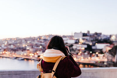 Woman in porto bridge taking pictures with camera at sunset. tourism in city europe. travel