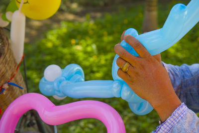 Close-up of hand holding multi colored balloons