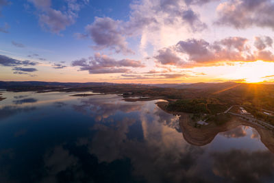 Drone aerial view of a lake reservoir of a dam with reflection on the water in sabugal, portugal