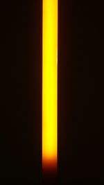 Close-up of yellow lamp against black background