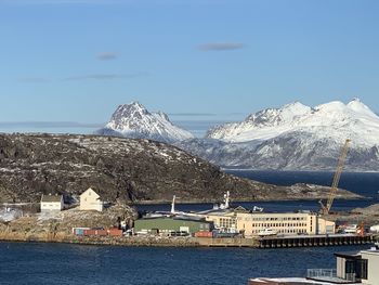 Scenic view of sea by buildings against sky