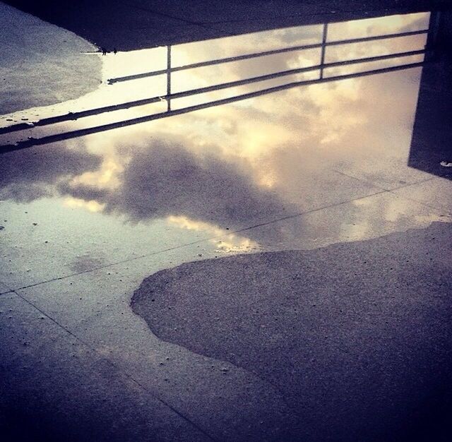 sky, transportation, cloud - sky, reflection, street, high angle view, built structure, low angle view, sunlight, road, architecture, day, connection, cloud, road marking, outdoors, shadow, no people, puddle, water