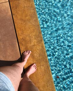 Low section of person standing by poolside