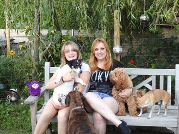 Portrait of smiling friends sitting with dog