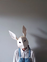 Woman wearing paper rabbit mask with space for text