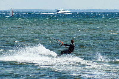 Man surfing in sea against sky