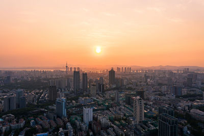 Aerial view of buildings in city against sky during sunset