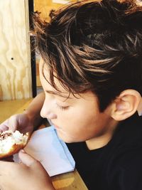 High angle view of boy eating food at table