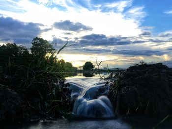 Scenic view of river against sky during sunset