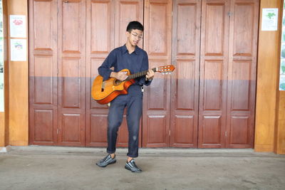 Full length of man playing guitar