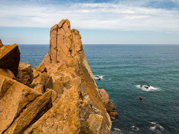 Scenic view of rocks in sea against sky