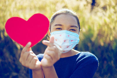 Portrait of boy holding heart shape