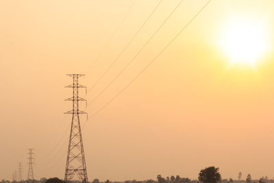 Low angle view of electricity pylons against clear sky