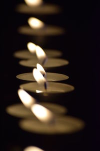 Close-up of illuminated candles on black background