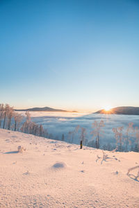 Fabulous winter scenery with a view of the sea of clouds illuminated by the sun in the morning