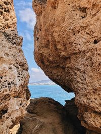Rock formations by sea against sky