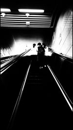 Rear view of man on escalator