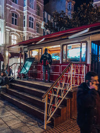 People standing by railing in city