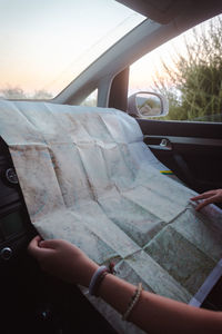 Hands of a woman on a map, road trip.