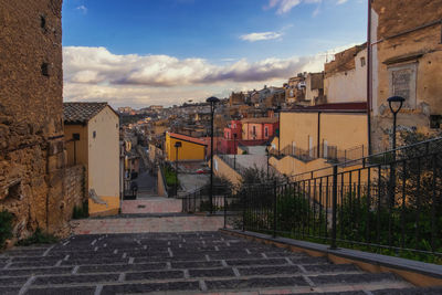 Street amidst buildings in town against sky