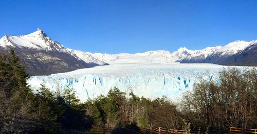 Scenic view of snowcapped mountains against clear blue sky