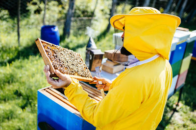 Side view of man holding yellow basket