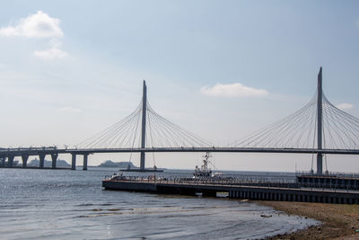 View of suspension bridge against cloudy sky