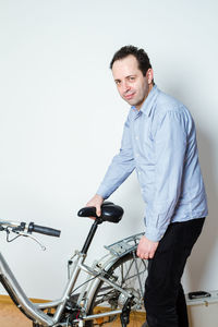 Portrait of young man standing on bicycle