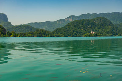 Scenic view of lake and mountains against clear sky