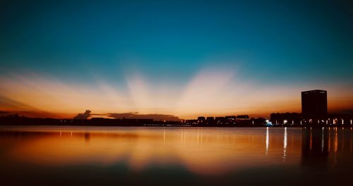 Scenic view of silhouette city against sky during sunset